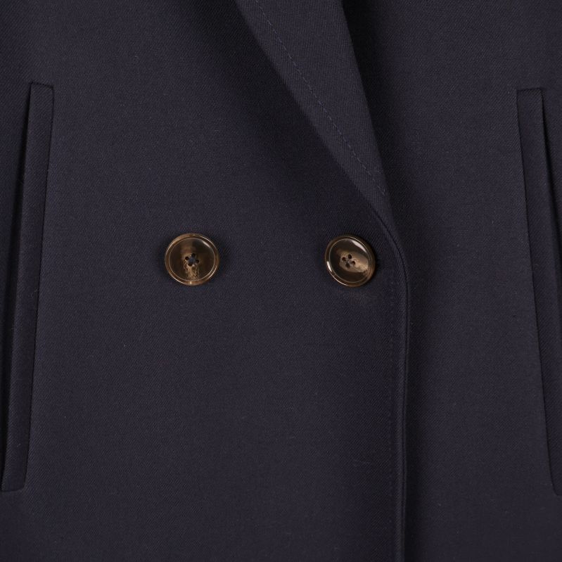 Närbild på knappar och fickor på kappa