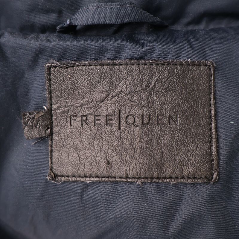 Närbild på FREQUENT logotyp i jackans krage