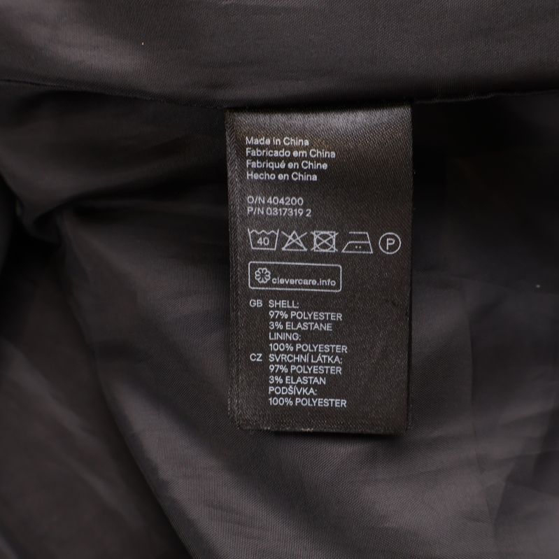 Materialetikett visar 96% polyester 3% elastan 1% polyamid