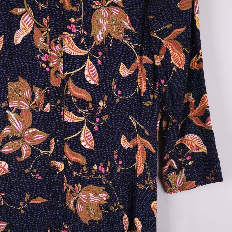 Detaljbild på ärm och blommigt tryck