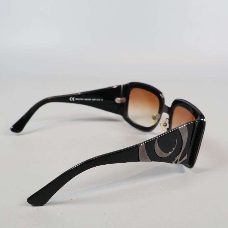 Solglasögon med breda svarta skalmar och dekordetaljer