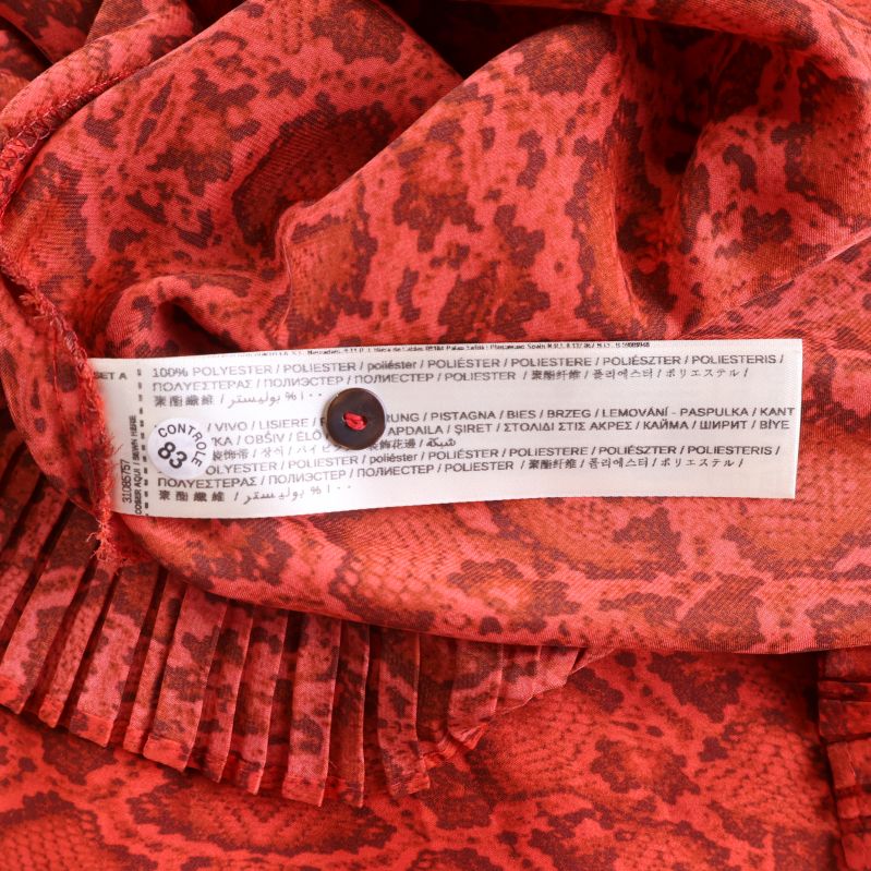 Materiallapp visar 100% polyester i flera språk