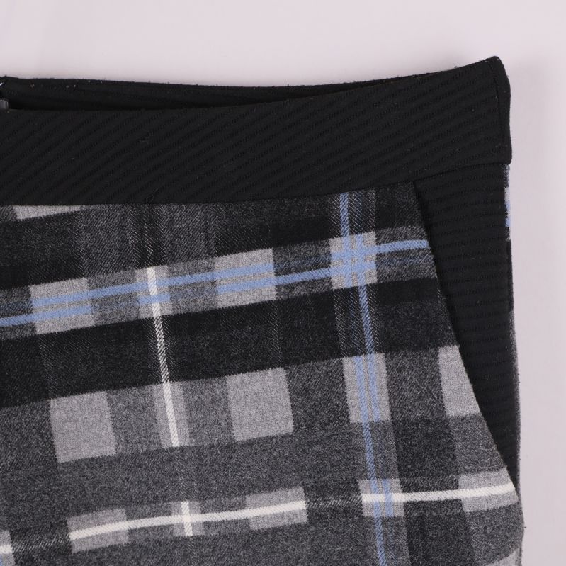 Detaljbild av kjolens svarta stretchpanel och rutmönster