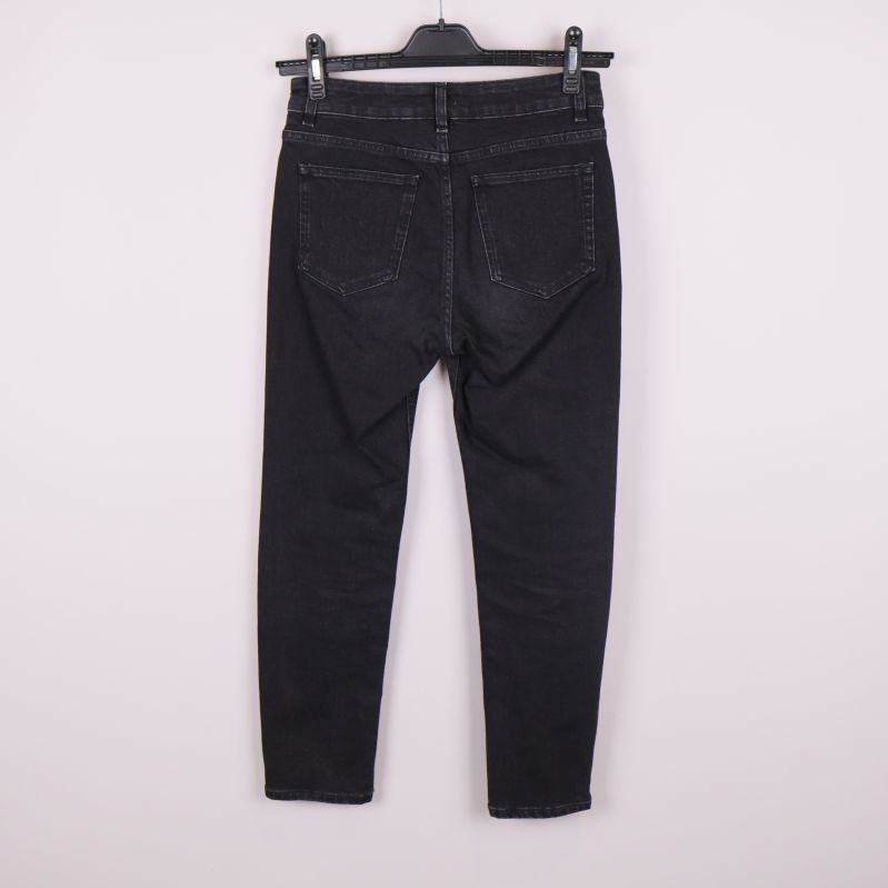 Baksida av svarta jeans med bakfickor synliga