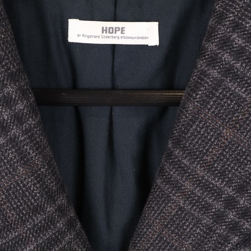 Närbild på HOPE-logga i kappans krage