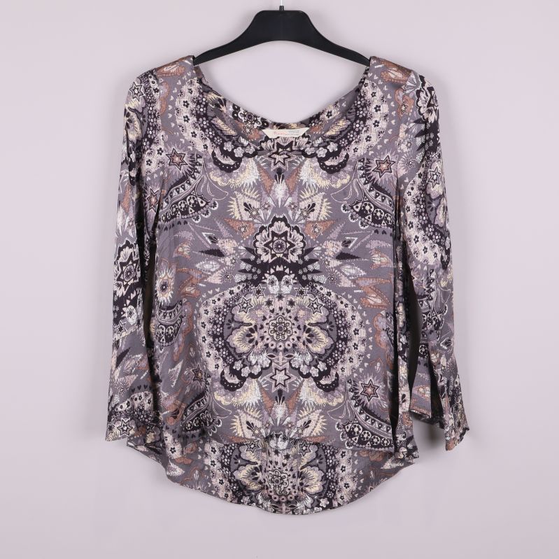 Topp med grafiskt mönster och utsvängda ärmar framifrån