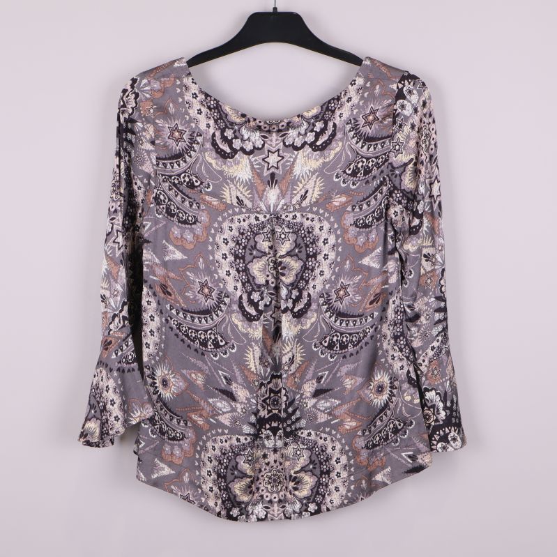 Topp med grafiskt mönster och utsvängda ärmar bakifrån