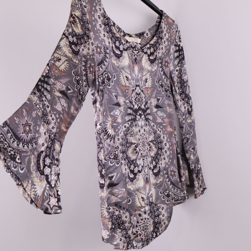 Topp med mönster i vinkel för att visa ärm