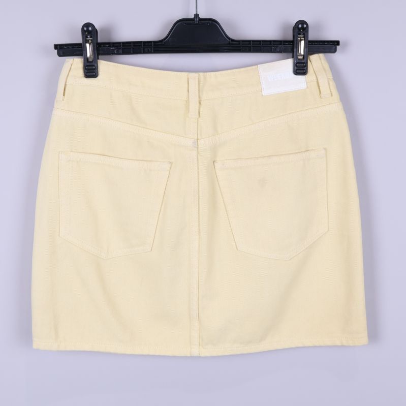 Baksidan av ljusgul kjol med två fickor och etikett