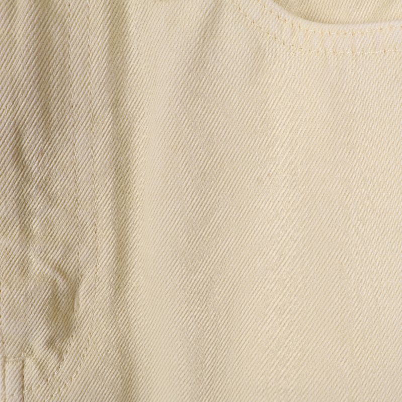 Tygstruktur i närbild visar ljusgul färg och väv