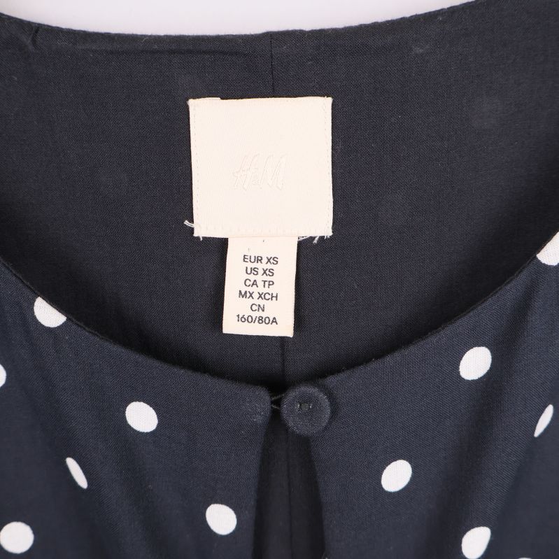 Nära bild på halsringning och H&M-etikett i klänningen