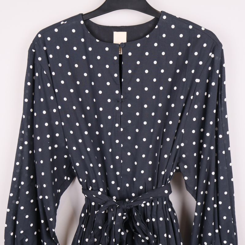 Övre delen av klänningen med knäppning i halsen och vita prickar