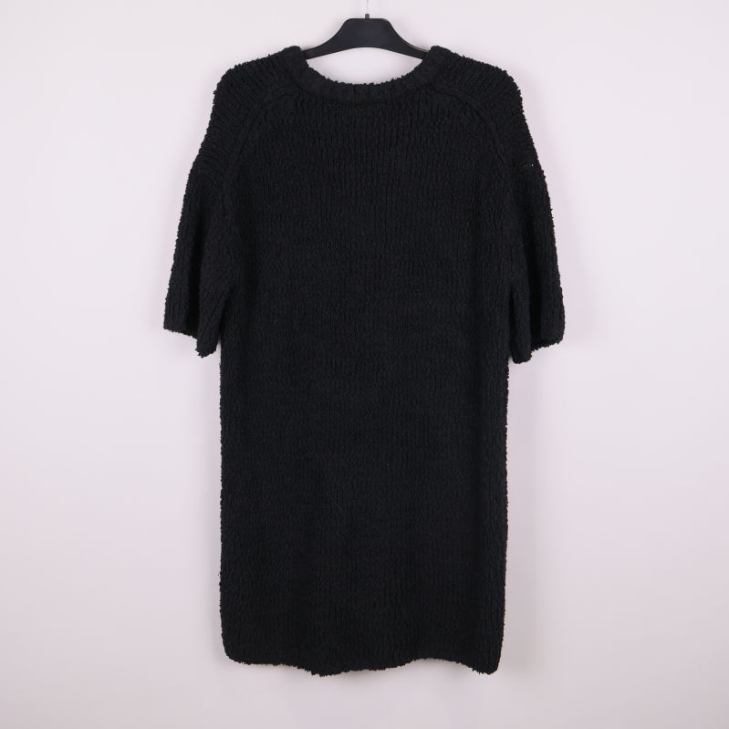 Svart stickad tröja fotad bakifrån på galge