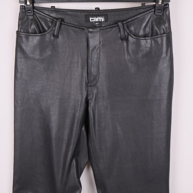 Främre detalj av byxlinningen och fickorna på svarta byxor