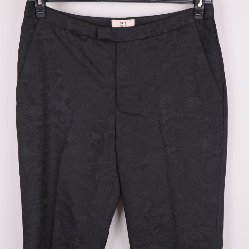 Närbild på framsidan av byxorna med fickor och struktur