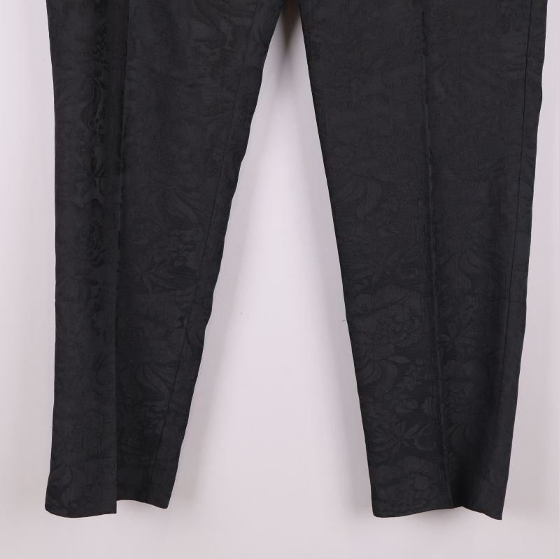 Närbild på benen av svarta byxor med struktur