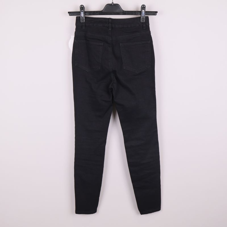 Baksida av svarta skinnyjeans med fickor