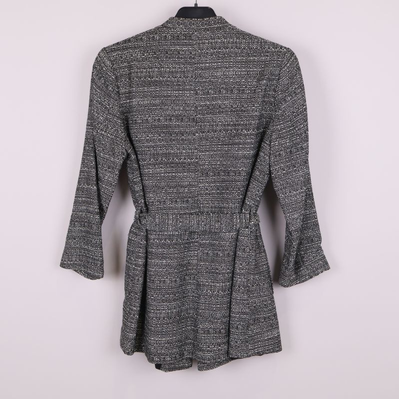 Kavajens baksida med svartvitt vävt mönster och elastisk midja