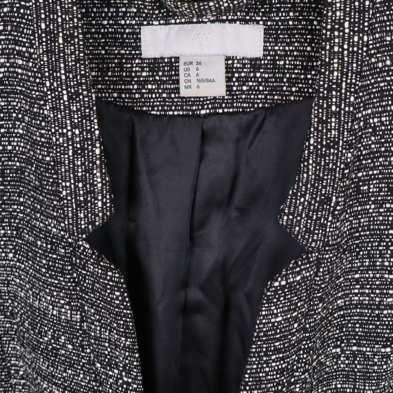 Närbild på kavajens etikett och storleksinformation vid kragen