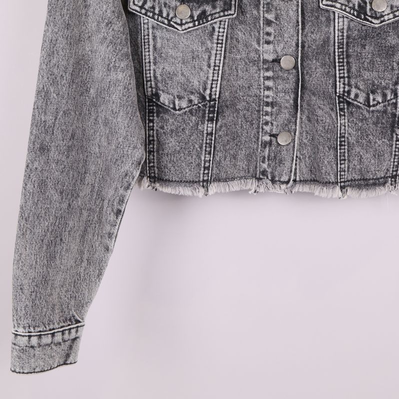 Närbild på ärm och rå nederkant av jeansjacka