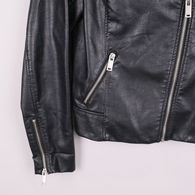 Närbild på nedre del av jacka med dragkedjor på fickor och ärmslut