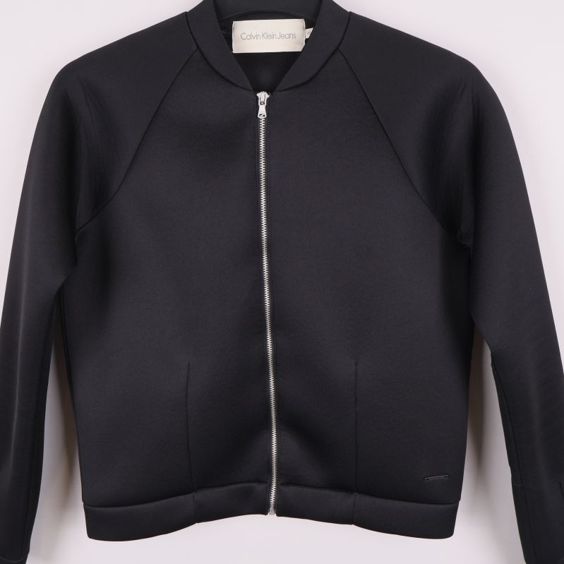 Svart bomberjacka sedd rakt framifrån med dragkedja stängd