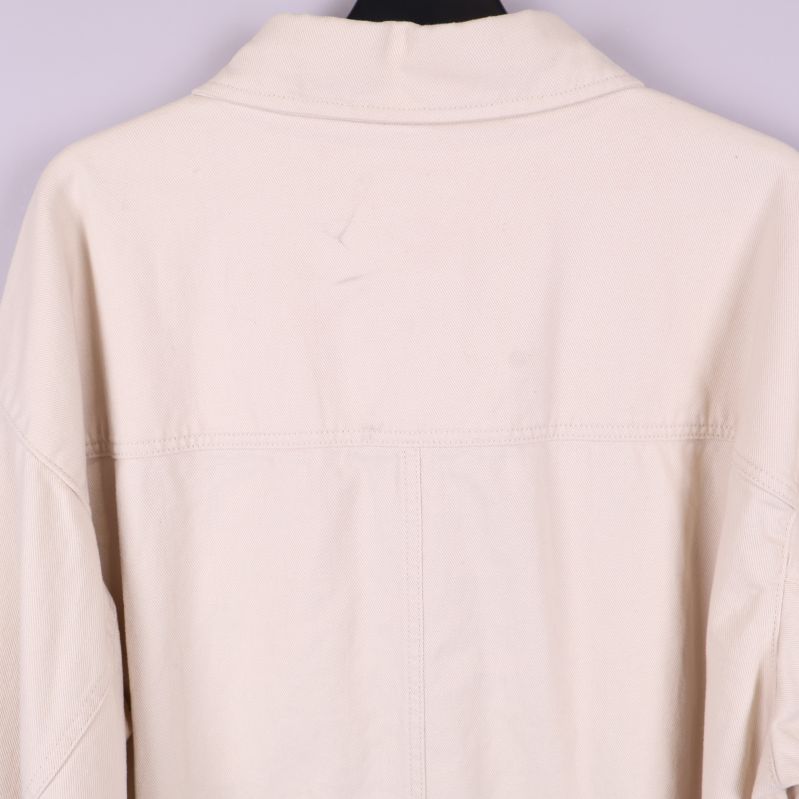 Närbild på övre ryggpartiet av beige overshirt
