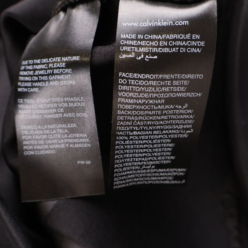 Materiallapp med information på flera språk inuti svart jacka