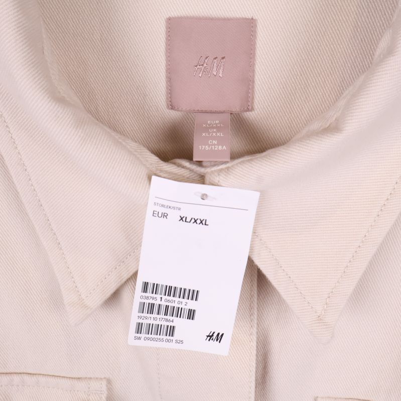 Kragdetalj och etikett på beige overshirt från H&M