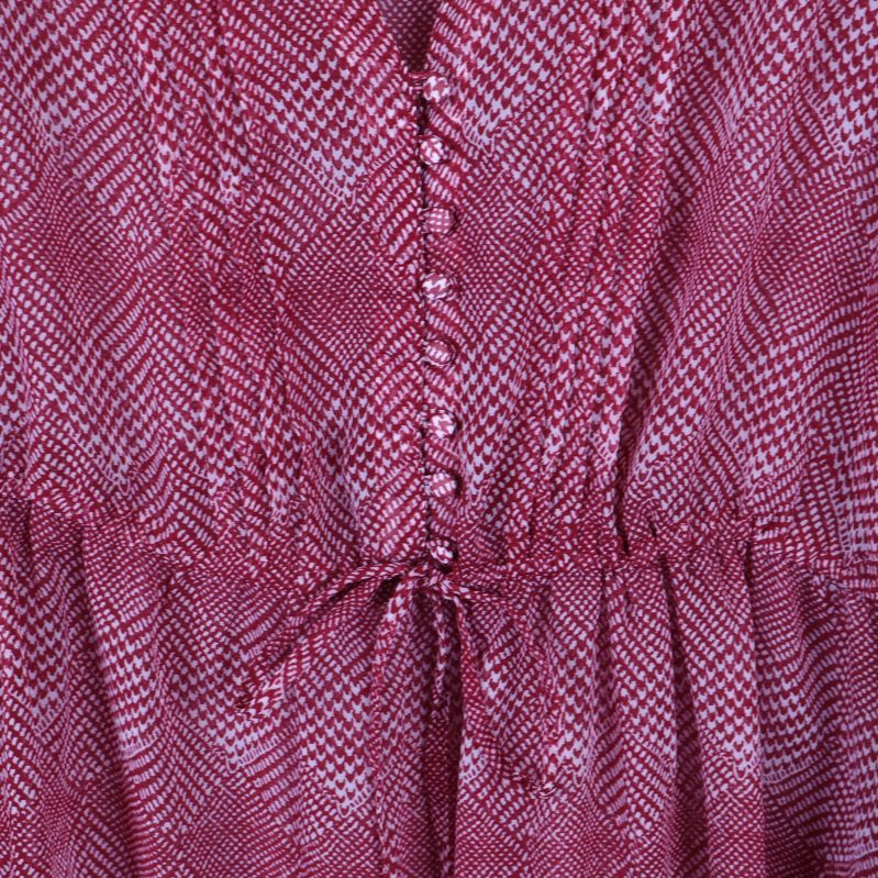 Närbild på knapprad och dragsko i midjan