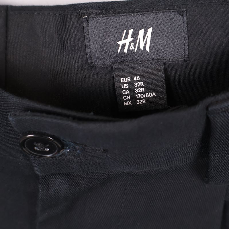 Närbild på H&M-etikett och storlekslapp i byxorna