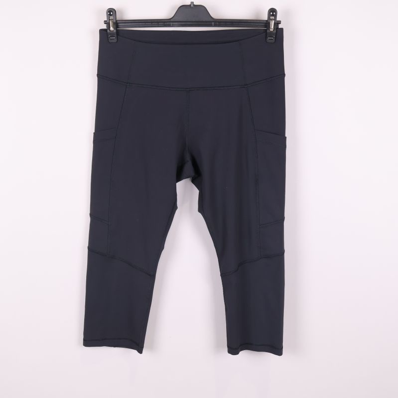 Framsida av svarta capri tights med höga fickor
