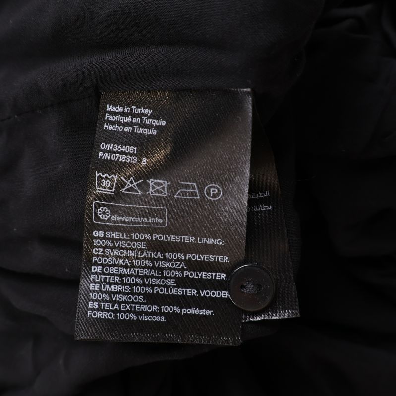 Materialetikett med innehåll: 100% polyester och fodrad med viskos