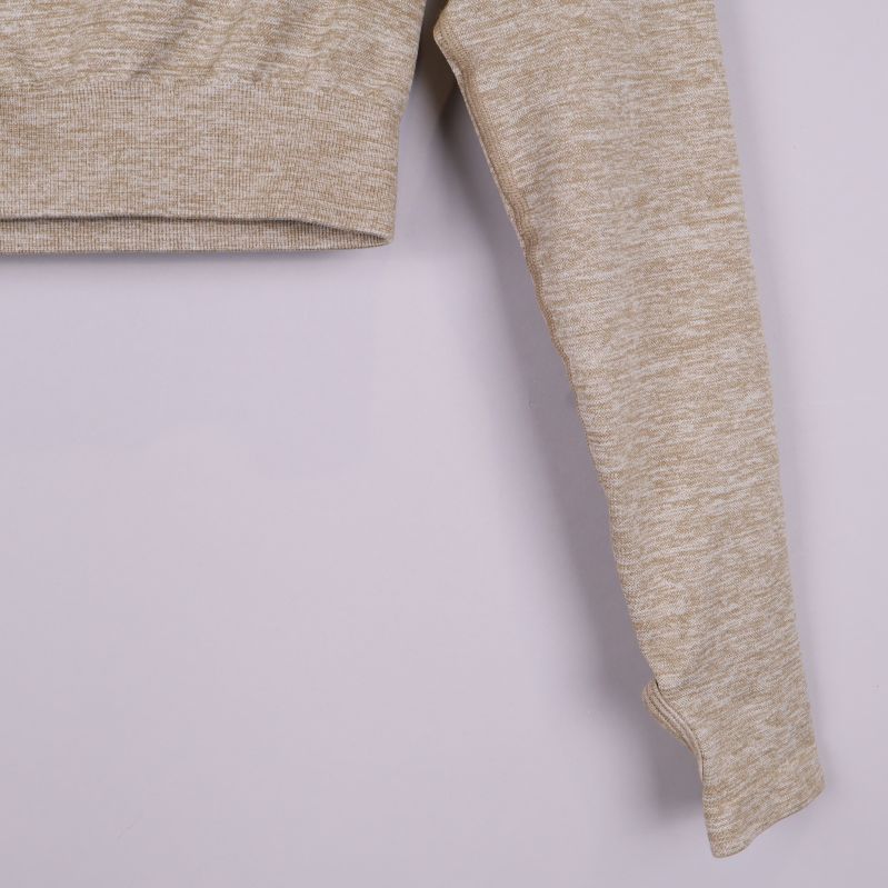 Närbild på beige tröjans ärm med tumhål