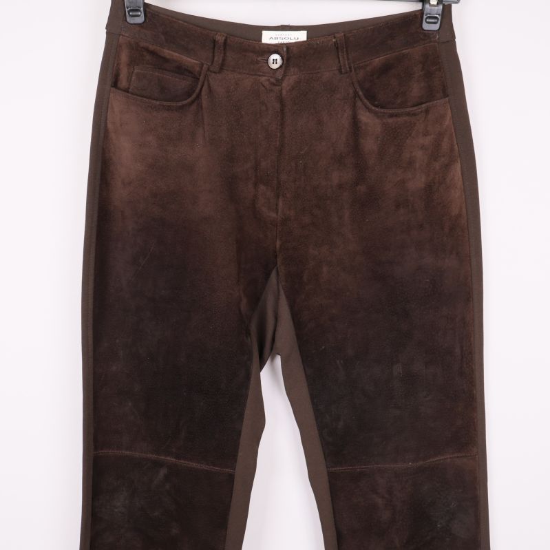 Närbild på framsidan av bruna byxorna med fickor och sömdetaljer