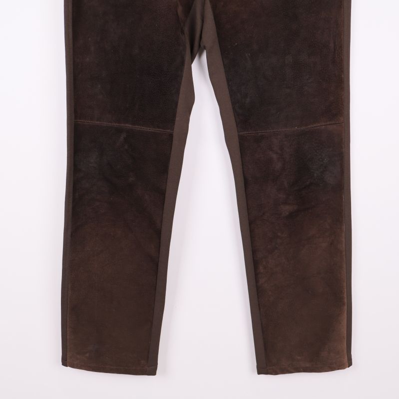 Närbild på benen av bruna velourbyxor med raka ben