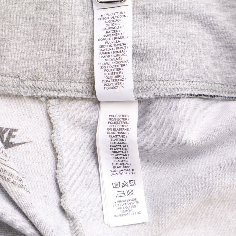 Materialetikett med innehåll 57% bomull, 32% polyester, 11% elastan