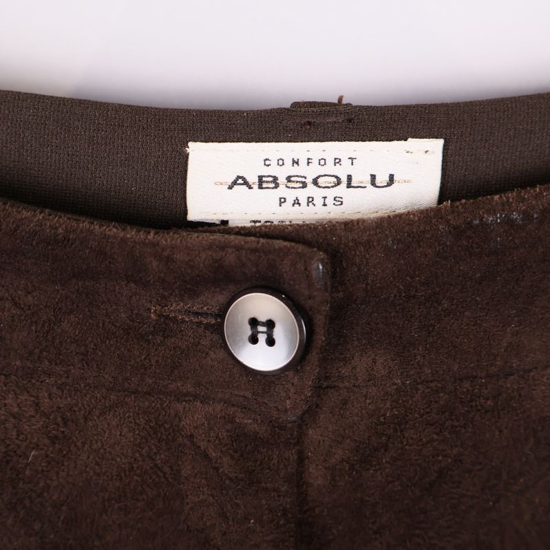 Närbild på midjan med Absolu Paris-logga och knapp