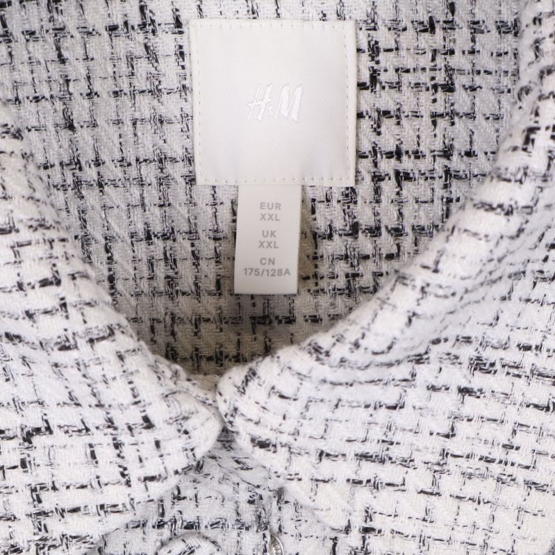 Närbild på etikett som visar H&M och storlek XXL