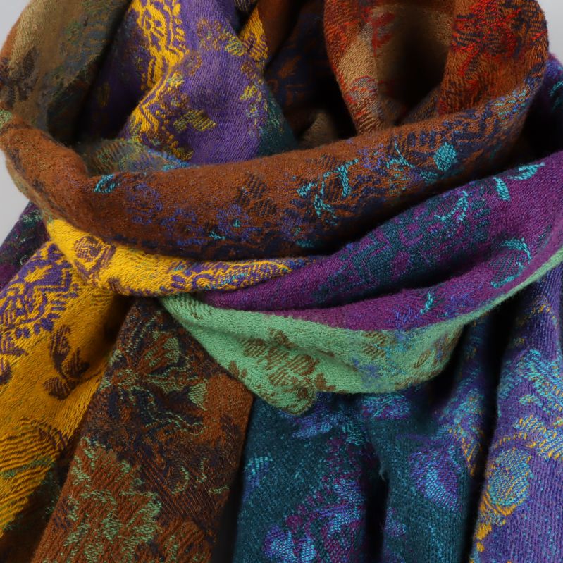 Närbild på sjalens lila, gröna och gula toner