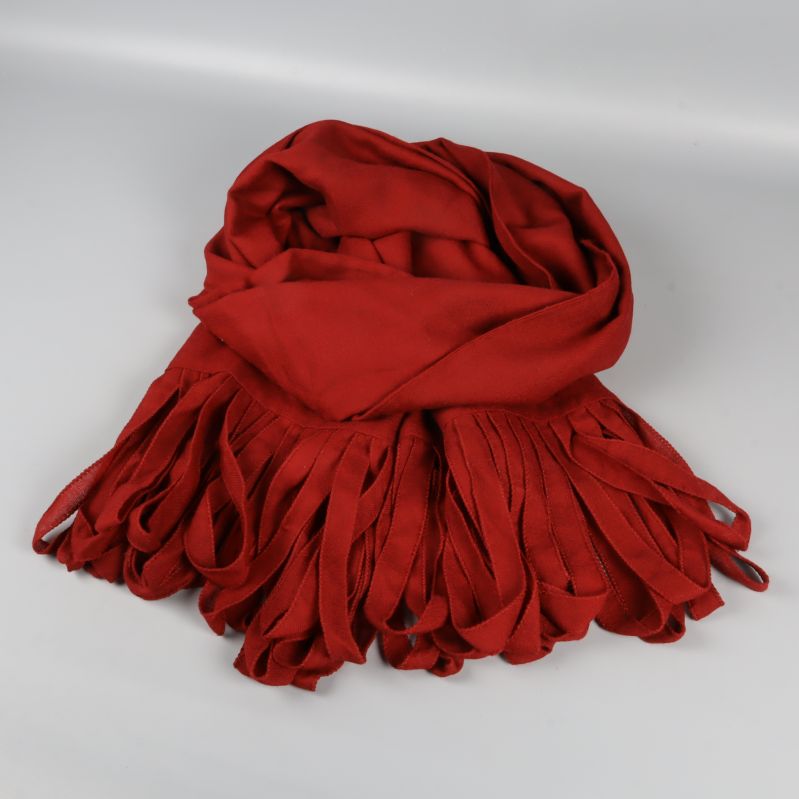 Röd scarf med långa fransar ligger vikt