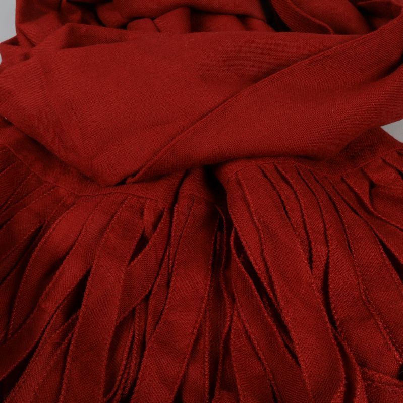 Närbild på röda fransar på scarfen