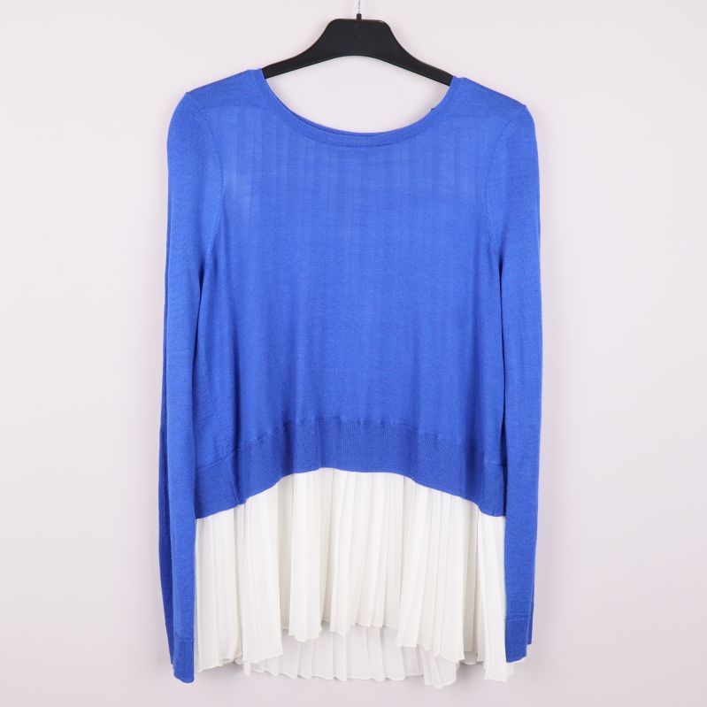 Framsidan av blå tröja med vit plisserad kant