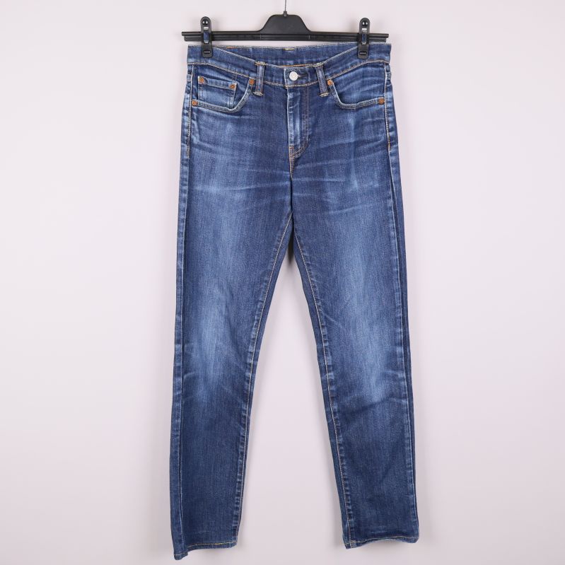 Framsidan av blåa smala jeans