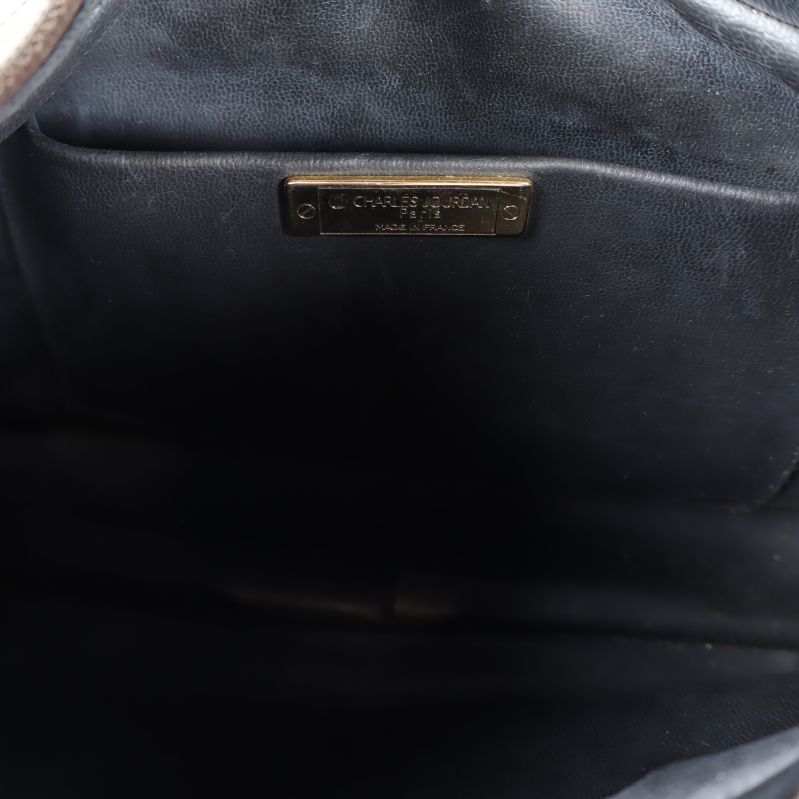 Insida av väska med Charles Jourdan-märke i metall