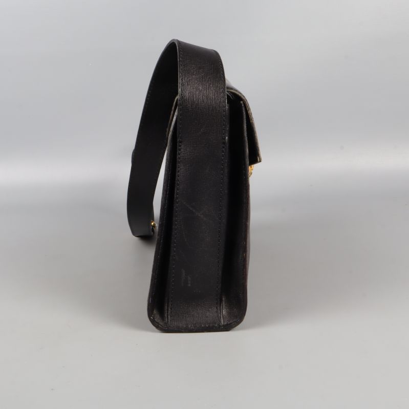 Sidosikt av svart axelremsväska