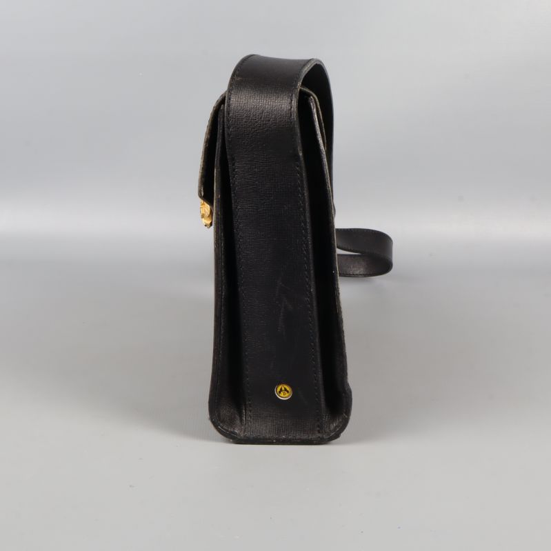 Sidovy på svart väska med liten gulddetalj