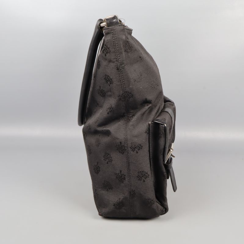 Sidovy av svart axelväska med diskret mönster