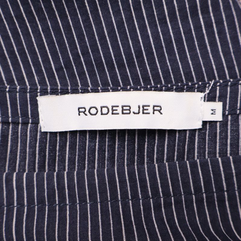 Närbild på Rodebjer-märke i halsen på randig blus