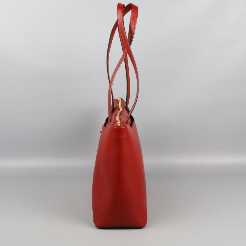 Smal sida av röd axelväska med långa handtag